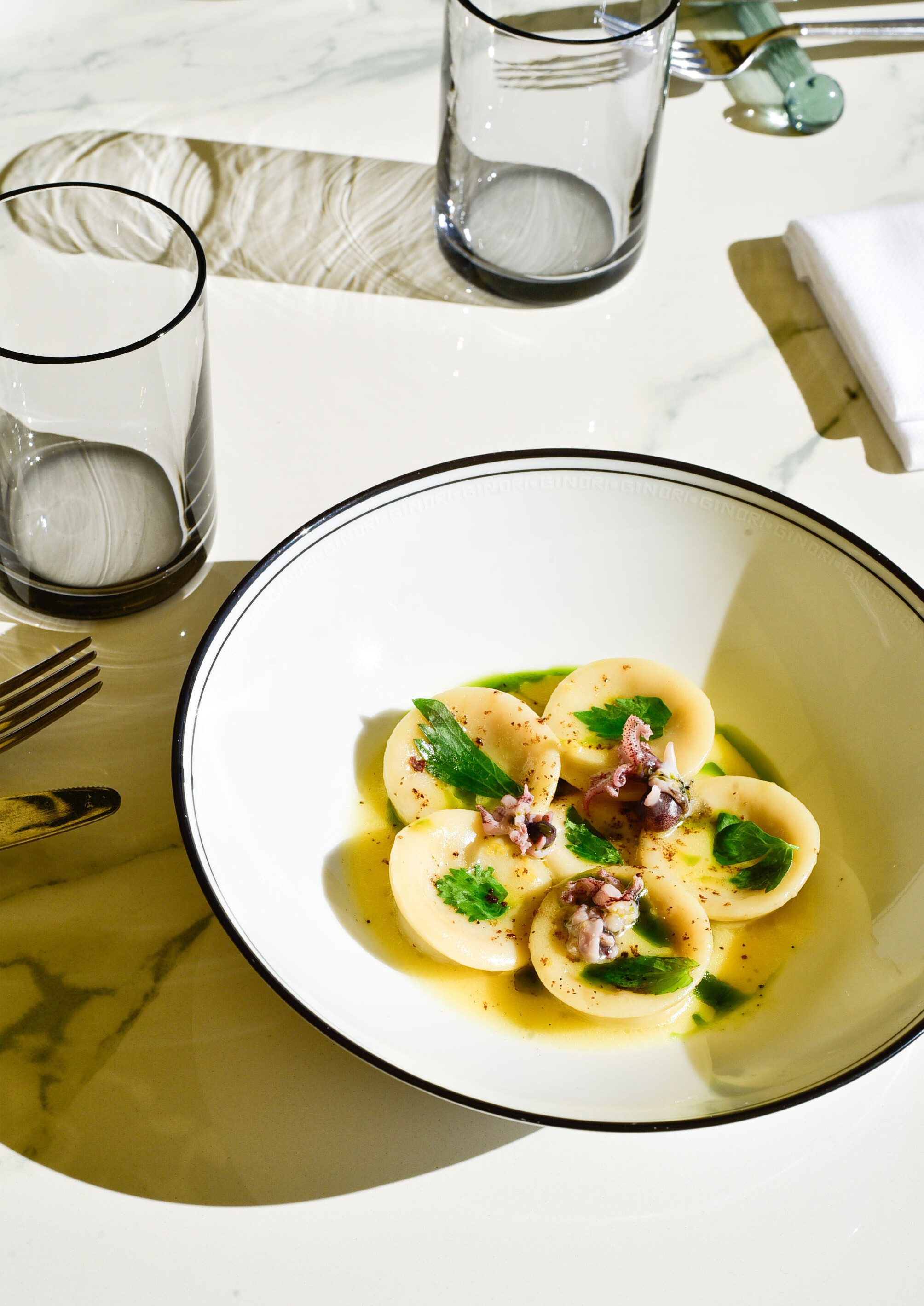Woman in white dress and gold earrings walking down runway